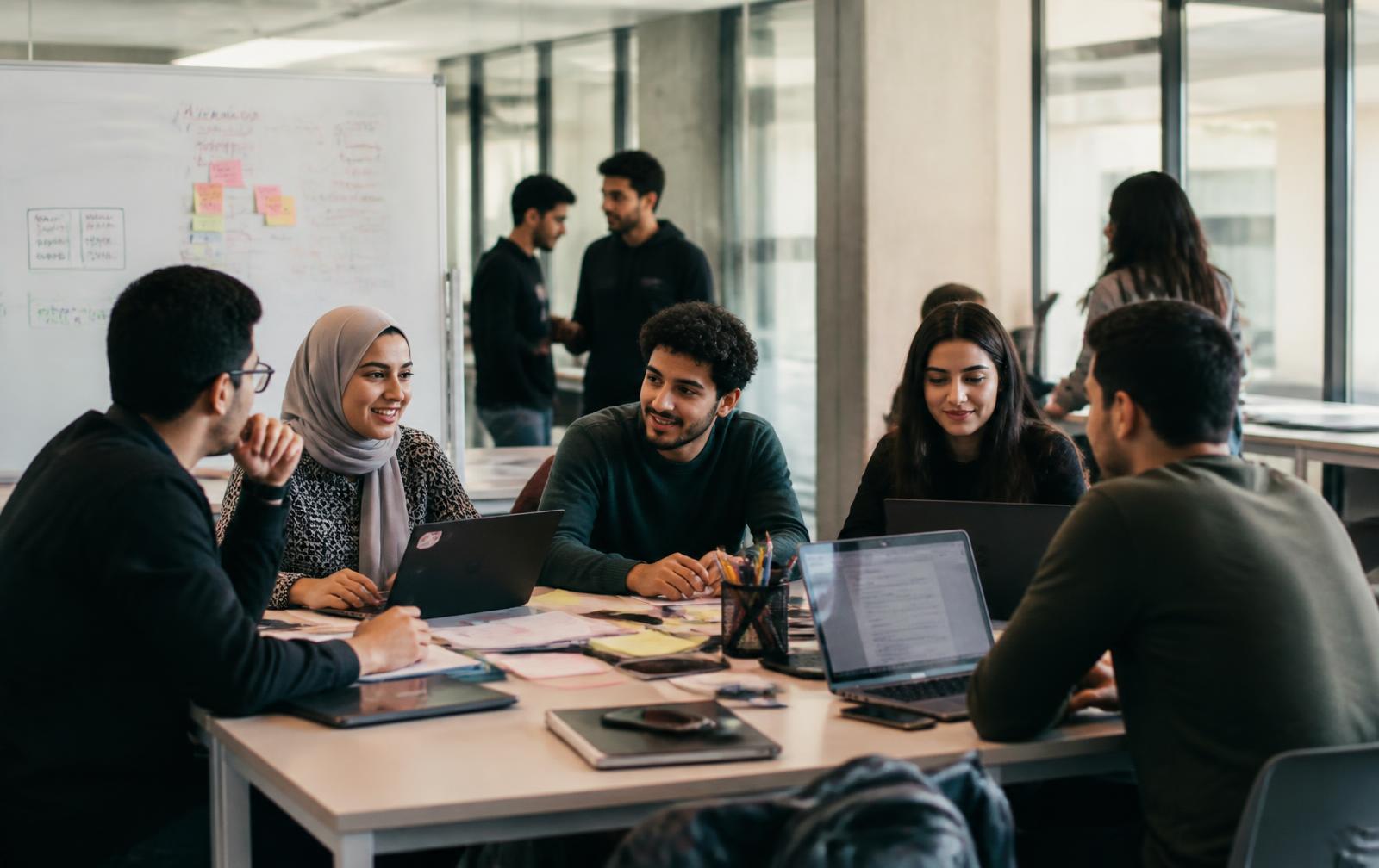 Jeunes entrepreneurs et étudiants en atelier dans un espace universitaire moderne